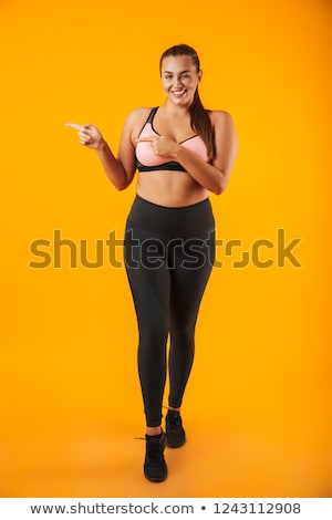 Foto d'archivio: Full Length Portrait Of Big Woman In Sportive Bra Smiling And Po