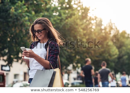 Stok fotoğraf: Women With Smartphones And Shopping Bags In City