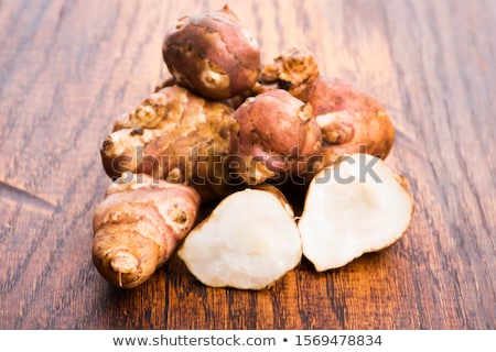 Stockfoto: Raw Whole Ans Sliced Jerusalem Artichokes On A Cutting Board