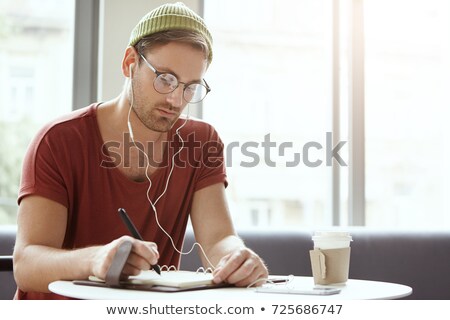 Foto d'archivio: Young Man Writing In Diary