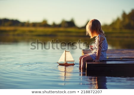 [[stock_photo]]: Young Girl Sitting At Pond