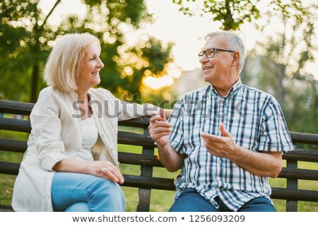 Stok fotoğraf: Older Couple Talking On Park Bench