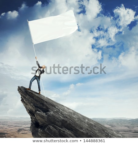 Stock photo: Businessman On The Top Of A Rock Holding Flag