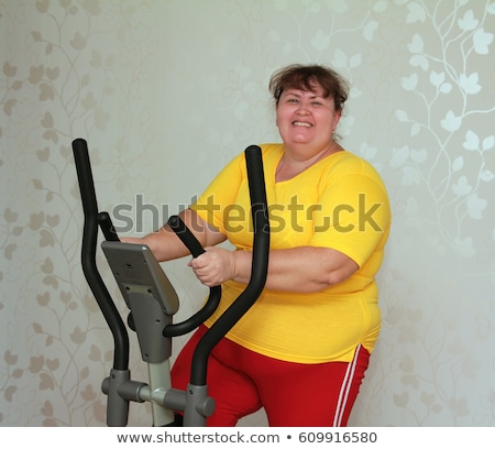 Zdjęcia stock: Overweight Woman Exercising On Bike Simulator