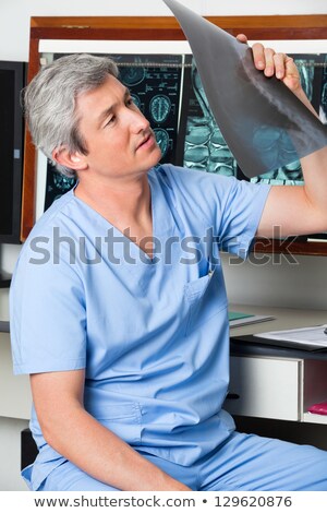 Foto d'archivio: Male Doctor Examining An Mri Report