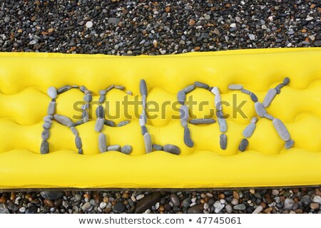 [[stock_photo]]: Relax Message From Pebbles On A Air Bed Air Bed Is Laying On A Sea Coast