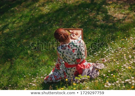 ストックフォト: Woman With Mirror Sitting In Blooming Meadow