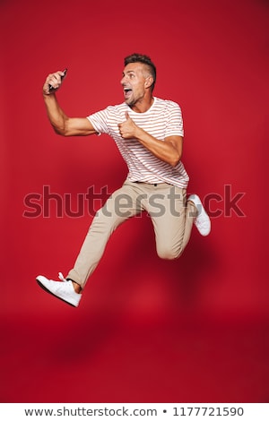 Foto d'archivio: Full Length Photo Of Caucasian Man In Striped T Shirt Jumping An