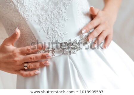 Foto d'archivio: Bride Putting On The Wedding Dress With A Decorated Belt