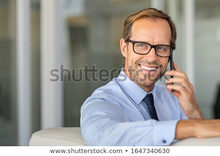 Stock photo: Image Of Happy Handsome Man In Formal Wear Sitting In Office Wit