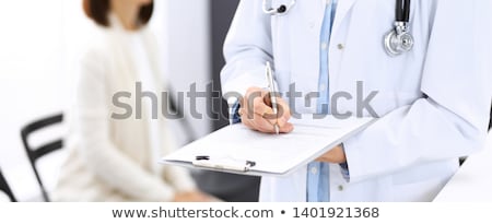 Zdjęcia stock: Close Up Of Doctor Filling Up An History Form While Consulting P