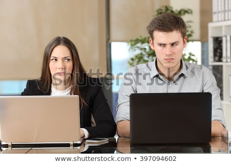 Foto stock: Businessman With Laptop Looking At Annoyed Young Businesswoman