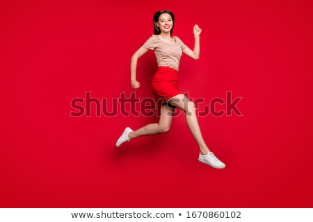 Stockfoto: Happy Smiling Girl In Red Shirt And Skirt Jumping