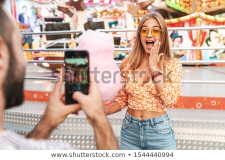 Stok fotoğraf: Young Couple Taking Photos With Smartphones In The Park