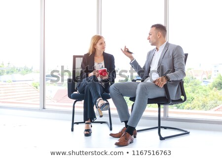 Stok fotoğraf: Young Businessman Or Office Worker With Two Cups Of Coffee Agrees On Smartphone With Friends Or Coll