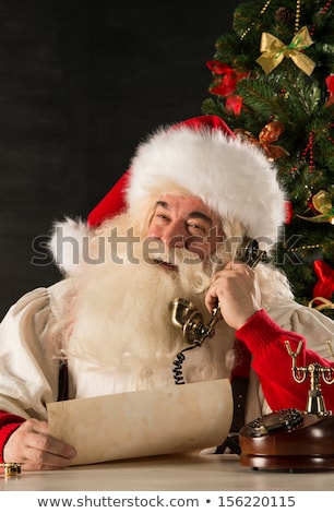 Stockfoto: Santa Claus Calling With Vintage Phone While Reading An Old Roll