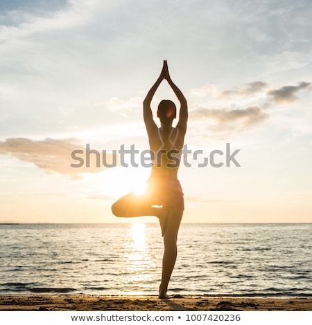 Young Woman Exercising While Standing On One Leg Stockfoto © Kzenon