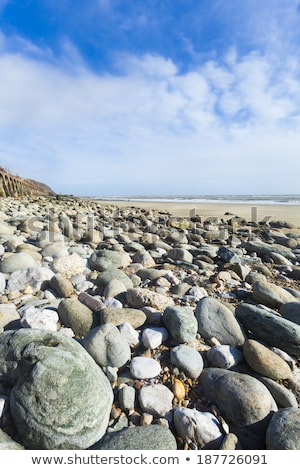 Foto d'archivio: Portrait Format Wide Angle Pebble Beach And Blue Sky