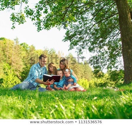 [[stock_photo]]: Young Family Reading The Bible In Nature