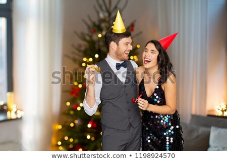 Stock fotó: Couple With Party Blowers Having Fun On Christmas