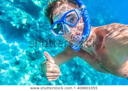 Zdjęcia stock: Young Male Diver Giving An Ok Hand Signal Wearing A Snorkle And Diving Glasses In An Indoor Swimmin