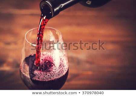 ストックフォト: Red Wine In Glass Against Red Background