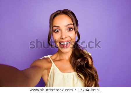 Foto stock: Pretty Brunette Girl With Long Wavy Hair Showing Stick Out And Taking Self Portrait On Her Smart Pho