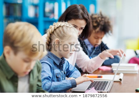 Stockfoto: Side View Of Focused Schoolboy Studying In Classroom Sitting At Desks In School