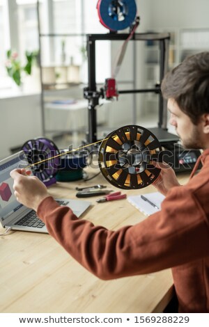 Stok fotoğraf: Designer Stretching Yellow Filament From Spool While Choosing Color For Printing