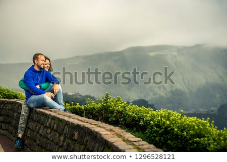 Stock fotó: Happy Young Couple In Love Sitting On A Mountain Hugging And Lo