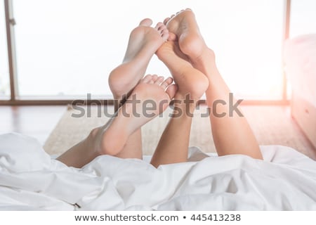 Foto stock: Close Up Of Couples Feet Sleeping On Bed