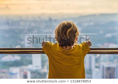 Foto stock: Little Boy Looks At Kuala Lumpur Cityscape Panoramic View Of Kuala Lumpur City Skyline Evening At S
