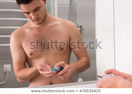 ストックフォト: Young Man Putting Some Shaving Foam Standing In The Bathroom Looking At The Camera