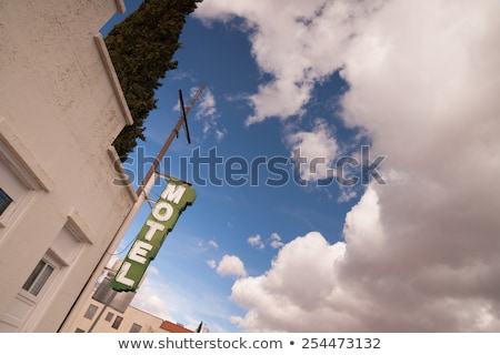 ストックフォト: Neon Motel Sign Clear Blue Sky White Billowing Clouds