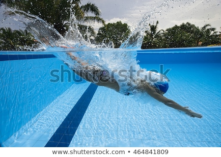 Foto stock: Woman Diving Underwater In Resort Swimming Pool