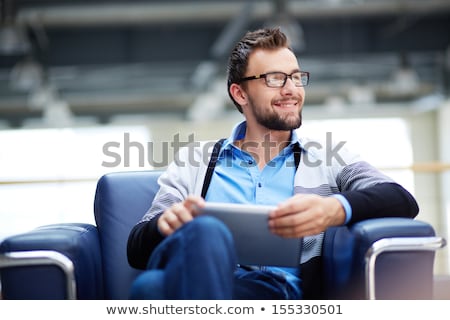 Stockfoto: Portrait Of Pensive Young Businessman Smiling And Sitting