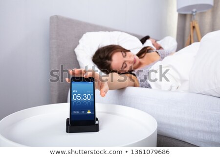 Foto stock: Woman Sleeping Near Alarm Set On Mobile Phone