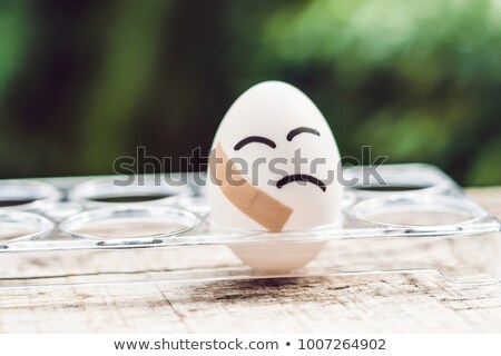 Foto stock: Broken Egg With Sticking Plaster Concept Of Brittleness And Pain