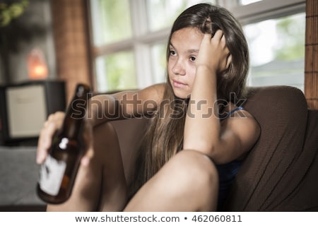 Foto stock: Sadness Teen Girl Sits On Sofa At Home Beer