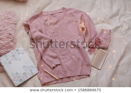 Foto d'archivio: Pink Sweater Phone And Pink Pillows Lie On The Sheet