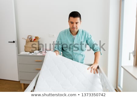 Foto stock: Father Arranging Baby Bed With Mattress At Home