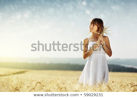 Stock fotó: Smiling Young Woman In White Dress On Cereal Field