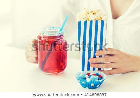Foto stock: Woman Eating Popcorn With Drink In Glass Mason Jar