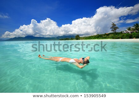 Stock fotó: Woman Lying On Water Against A Blue Background