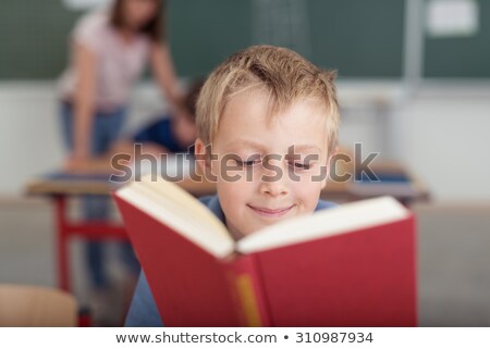 ストックフォト: 学校のクラスで読んでいる男子生徒と彼の先生