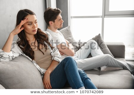 Foto d'archivio: Photo Of Resentful Guy And Girl Sitting Together On Couch At Hom
