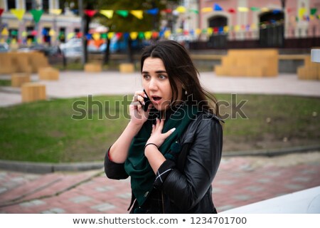 Foto stock: Surprised Businesswoman Walking Down The Street While Talking On