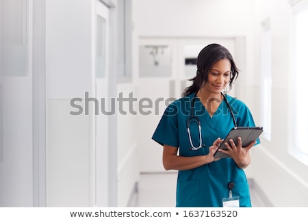 Сток-фото: Female Doctor Using Digital Tablet In Corridor