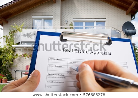 Foto stock: Person Filling Document In Front Of House