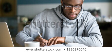 Stock fotó: Handsome Student Working On An Essay In The Library